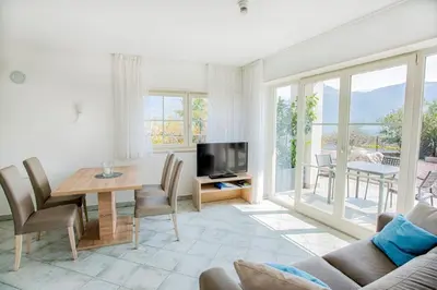a living room with a couch and a table and a television at Residence Roland in Caldaro