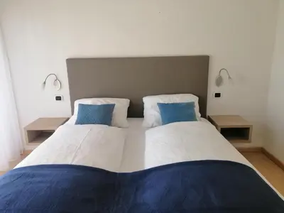 two beds sitting next to each other in a bedroom at Residence Roland in Caldaro
