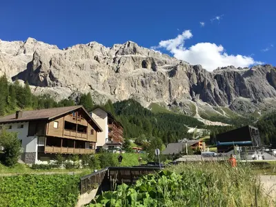 a house in a village with a mountain in the background at Chalet Albric in Selva di Val Gardena