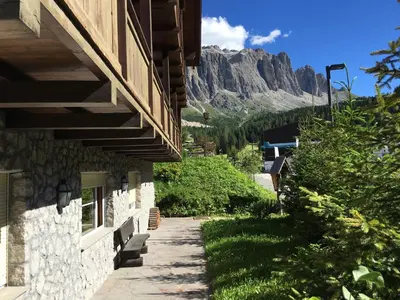 a path next to a building with a mountain in the background at Chalet Albric in Selva di Val Gardena