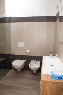 a bathroom with a toilet and a bidet and a sink at Loft 82 Apartments in Bolzano