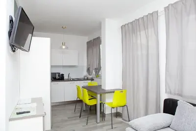a kitchen with a table and yellow chairs in a room at Loft 82 Apartments in Bolzano