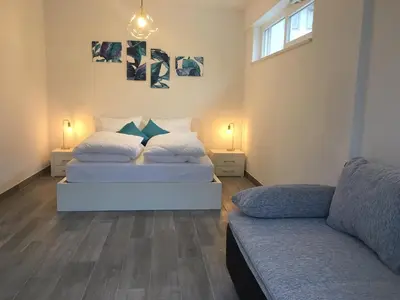 two beds in a room with a couch at Loft 82 Apartments in Bolzano