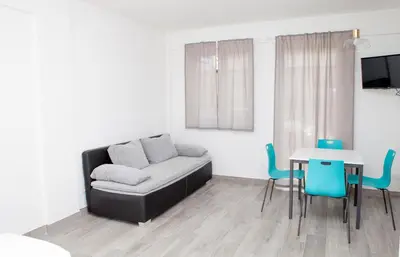 a living room with a couch and a table and chairs at Loft 82 Apartments in Bolzano