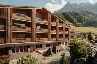 an image of a hotel with mountains in the background at Hotel Diamant in San Cassiano