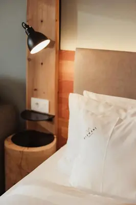 a bedroom with a bed with a pillow and a lamp at Hotel Diamant in San Cassiano