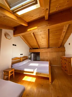 a bedroom with a large bed in a wooden ceiling at Casa Fiemme Panchià in Panchia