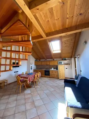 a living room with a table and a couch at Casa Fiemme Panchià in Panchia