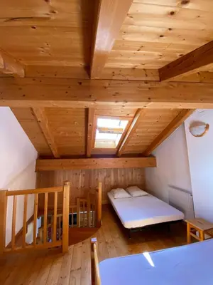 a room with a bed and a wooden ceiling at Casa Fiemme Panchià in Panchia