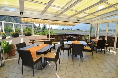 a restaurant with tables and chairs on a patio at Haus Winkler in Vilpiano