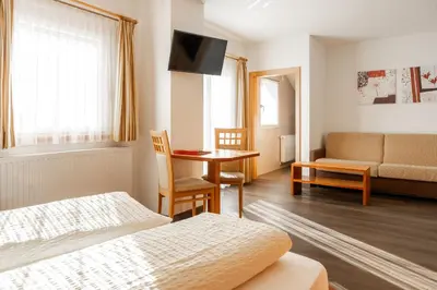 a hotel room with a bed and a table and a couch at Haus Winkler in Vilpiano