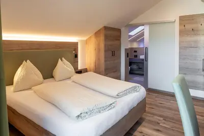 a bedroom with a large bed with white sheets at Haus Winkler in Vilpiano