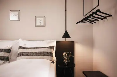 a bedroom with a bed with white pillows and a lamp at Hotel Löwenhof in Bressanone