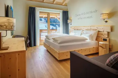 a bedroom with a large bed and a window at Plang Farmhouse in San Cassiano