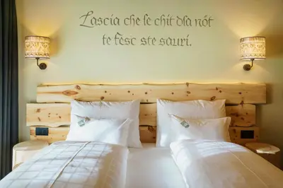 a bedroom with two beds and a sign on the wall at Plang Farmhouse in San Cassiano