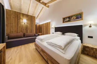 a bedroom with a large bed and a couch at Plang Farmhouse in San Cassiano