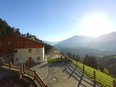 a building on a hill with a view of a valley at Chalet Flierer in Rodengo