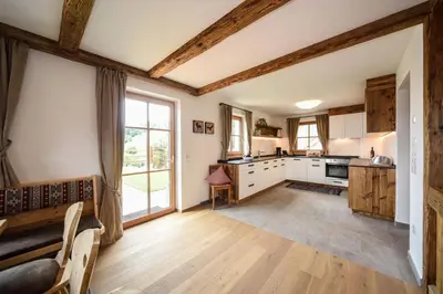 a kitchen with white cabinets and a large window at Chalet Flierer in Rodengo