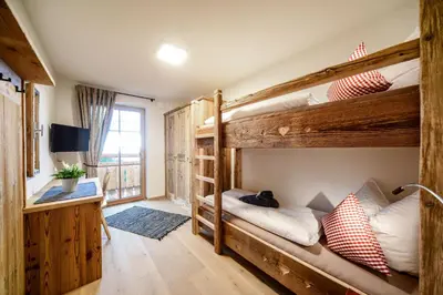 a room with two bunk beds and a desk at Chalet Flierer in Rodengo