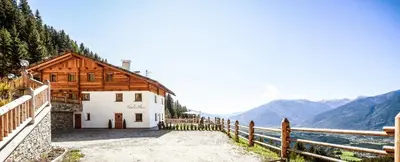 a building with a fence next to a body of water at Chalet Flierer in Rodengo