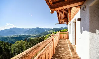 a wooden balcony with a view of mountains at Chalet Flierer in Rodengo