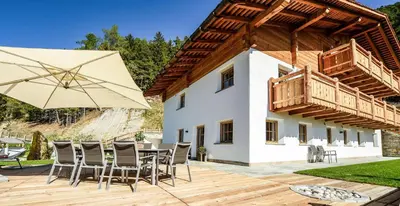 a patio with a table and chairs and an umbrella at Chalet Flierer in Rodengo