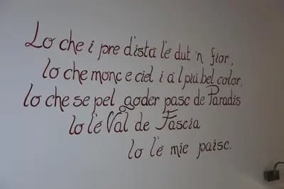 a wall with a writing on the wall at Garnì Ladin in Vigo di Fassa