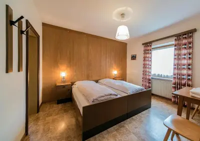 a bedroom with a large bed and a window at Residence Trametsch in Bressanone
