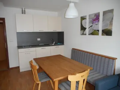 a kitchen with a wooden table and a blue couch at Residence Trametsch in Bressanone