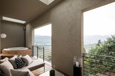a balcony with a couch and a view of the mountains at Designhotel Gius La Residenza in Caldaro