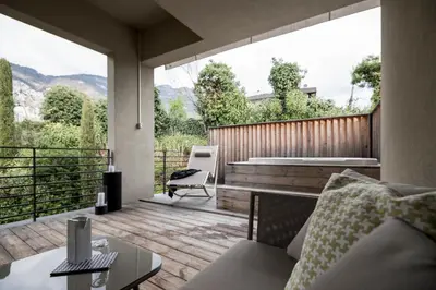 a living room with a couch and a large window at Designhotel Gius La Residenza in Caldaro
