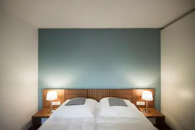 a bedroom with a large bed with two lamps on it at Designhotel Gius La Residenza in Caldaro