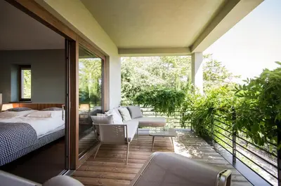 a master bedroom with a bed and a balcony at Designhotel Gius La Residenza in Caldaro