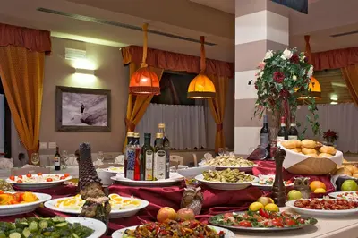 a table with many plates of food and bottles of wine at GH Hotel Piaz in Pozza di Fassa