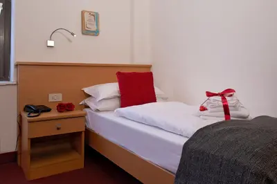 a bedroom with a bed with a red bow on it at GH Hotel Piaz in Pozza di Fassa