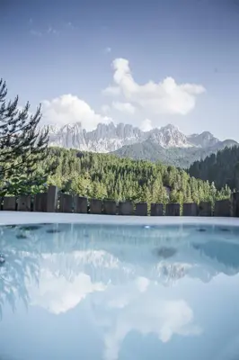 a pool of water with mountains in the background at Bike & Ski Hotel Diana Karersee in Nova Levante