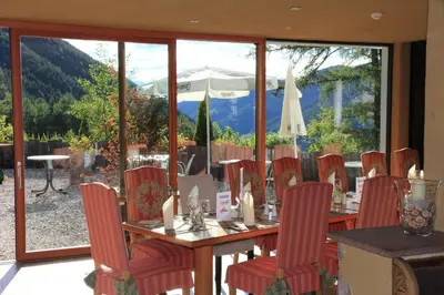 a dining room with a table and chairs with a view at Bike & Ski Hotel Diana Karersee in Nova Levante