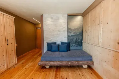 a bed in a room with a painting on the wall at Bike & Ski Hotel Diana Karersee in Nova Levante