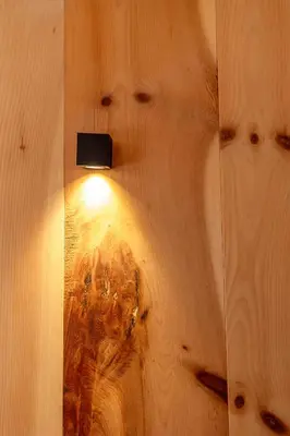 a light on a wooden wall with a light on it at Bike & Ski Hotel Diana Karersee in Nova Levante