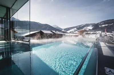 a swimming pool with steam coming out of the water at Hotel Fameli in Valdaora