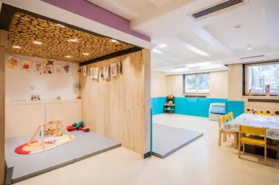 a childrens room with a table and a dining room at Hotel Fameli in Valdaora