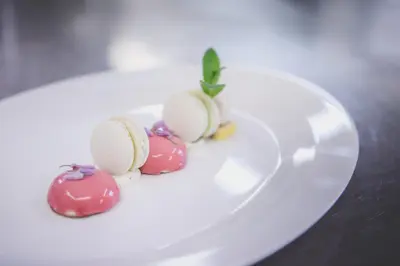 a white plate with three different colored desserts on it at Hotel Fameli in Valdaora