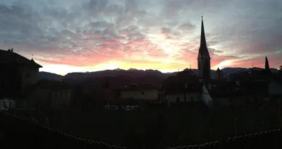 a sunset over a town with a church tower at Villa KaTo in Caldaro
