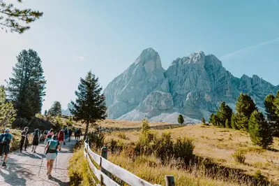 a group of people walking on a trail in the mountains at Hotel Bergschlössl in Luson