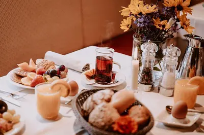 a table topped with plates of food and candles at Hotel Bergschlössl in Luson