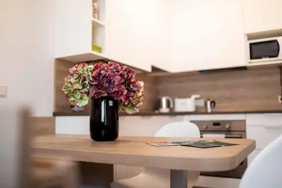 a vase of flowers sitting on a table in a kitchen at Pixner Apartments in Bolzano