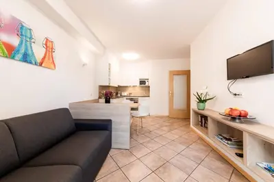 a living room with a couch and a kitchen at Pixner Apartments in Bolzano