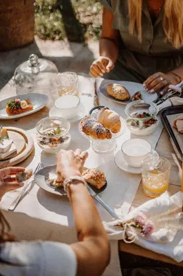 a group of people sitting at a table eating food at Farmhouse Torgglerhof in Saltusio