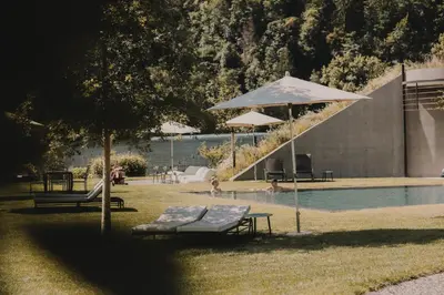 a pool with a table and an umbrella and a bench at Farmhouse Torgglerhof in Saltusio