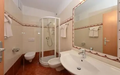 a bedroom with a red bed and a table with a table sidx sidx at Hotel Zirmes in Moena